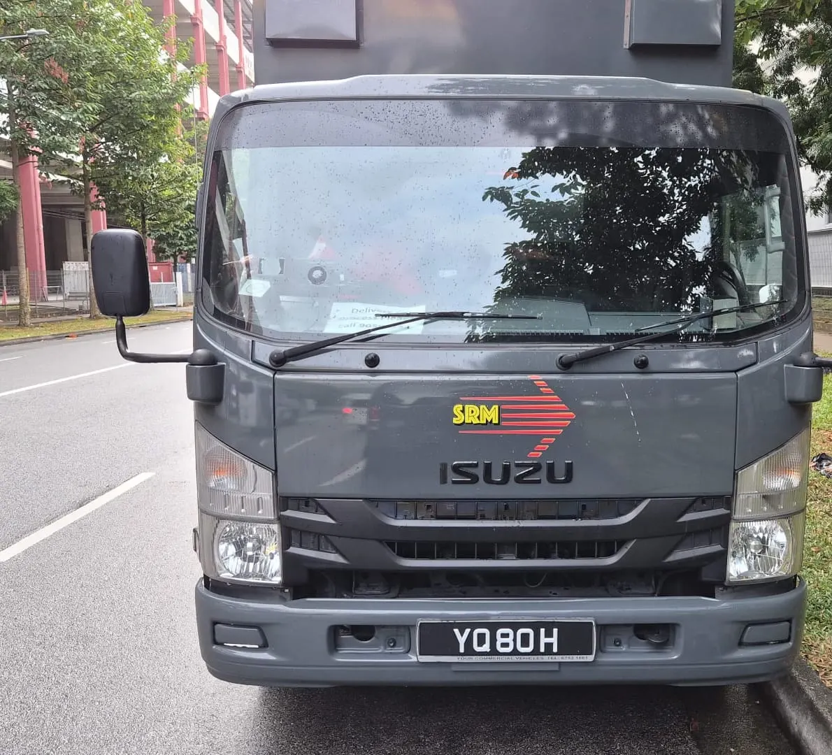 SRM Logistics Isuzu box lorry with tailgate, front view.